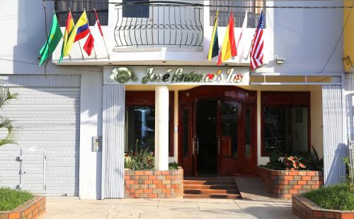 a building with several different flags in front of it at Hotel Jose Antonios Inn in Puerto Maldonado