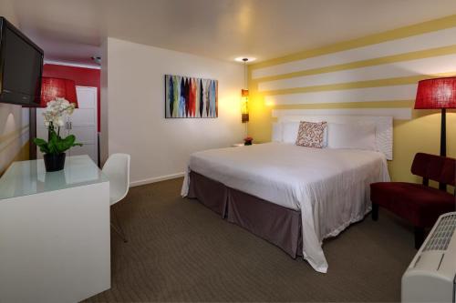 a hotel room with a large bed and a desk at Aqua Soleil Hotel and Mineral Water Spa in Desert Hot Springs
