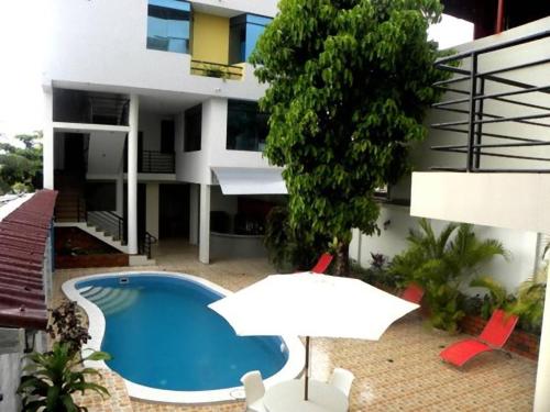 an apartment with a swimming pool and a building at Hotel Jose Antonios Inn in Puerto Maldonado