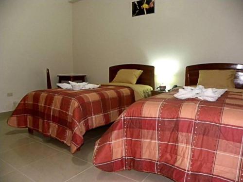 two beds sitting next to each other in a room at Hotel Jose Antonios Inn in Puerto Maldonado