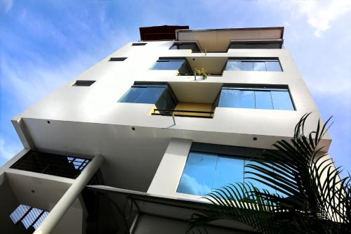 a white building with many windows on the side of it at Hotel Jose Antonios Inn in Puerto Maldonado