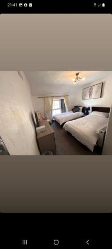 a bedroom with two beds and a table with a bedsenalsenalsenalsenalangering at Ardhill House B&B The Diamond, in the Heart of Ardara Town , F94 C7X9 in Ardara
