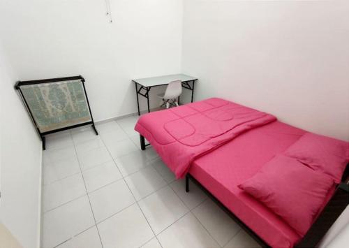 a bedroom with a pink bed and a table at D'Luna Homestay Melaka Fully Aircond in Melaka