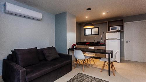 a living room with a couch and a table and a kitchen at Flat em Lagoa Nova, Mobiliado e Aconchegante in Natal