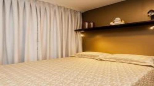 a bedroom with a bed and a window with curtains at Flat em Lagoa Nova, Mobiliado e Aconchegante in Natal
