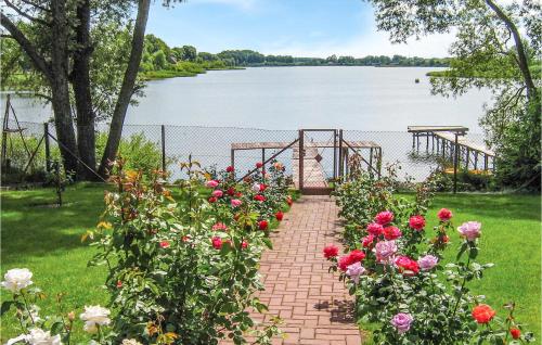a brick pathway with flowers in front of a body of water at Holiday Home Dzwierzuty Saplaty Iii in Dźwierzuty