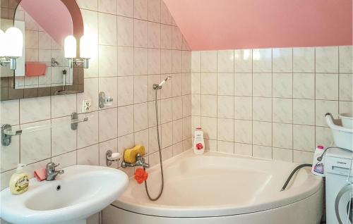 a bathroom with a sink and a bath tub at Awesome Home In Dzwierzuty With 3 Bedrooms And Wifi in Dźwierzuty