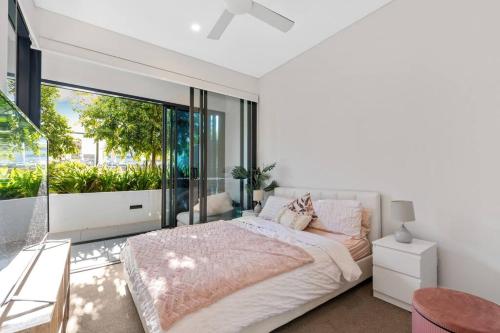 a bedroom with a bed and a large window at Great located unit/Private Balcony, Pool,Gym,Parking in Brisbane