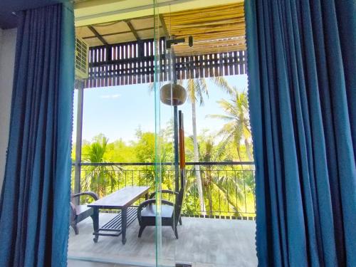 a patio with a table and chairs on a balcony at Nha Bong Villa in Hoi An