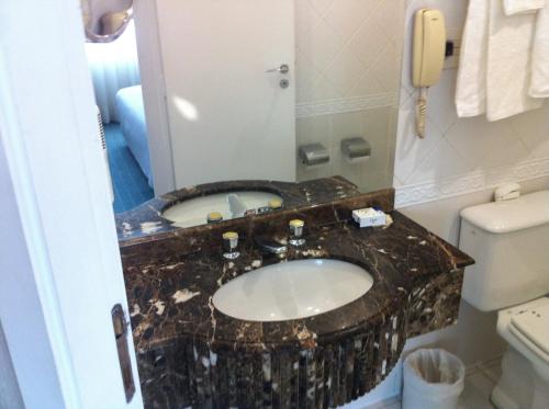 baño con lavabo, aseo y teléfono en Flats na Vila Olimpia, en São Paulo