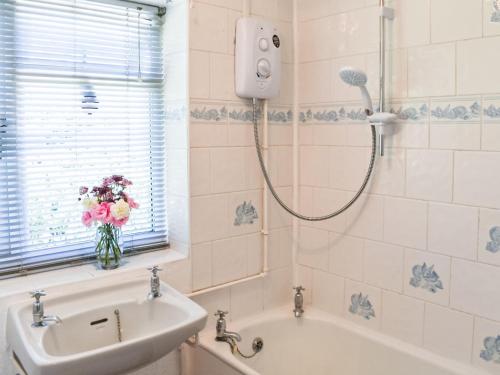 a bathroom with a shower with a vase of flowers at Valley View in Upper Arley