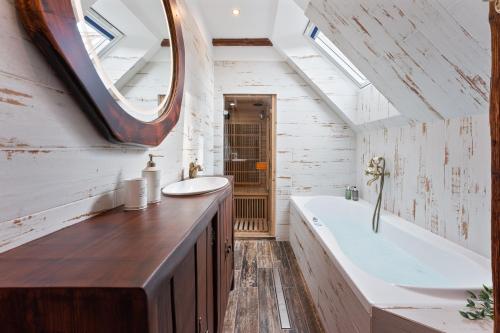 a bathroom with a tub and a sink and a mirror at Villa Libosad in Jičín
