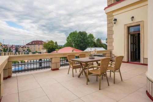 a patio with a table and chairs on a balcony at Villa Libosad in Jičín