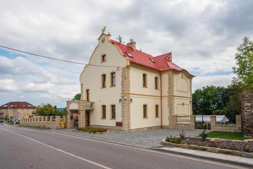 a building with a red roof on the side of a road at Villa Libosad in Jičín