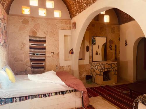 1 dormitorio con 1 cama en una habitación con arcos en Moon_Valley_Siwa en Siwa