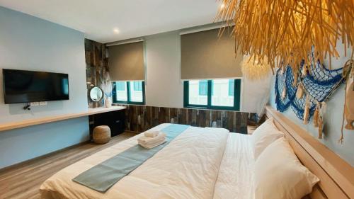 a bedroom with a bed and a tv and windows at 8BR West coast Phu Quoc townhouse by beach and shared swimming pools in Phú Quốc
