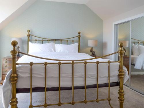 a bedroom with a large bed with white sheets at Inver House Apartment in Inverurie