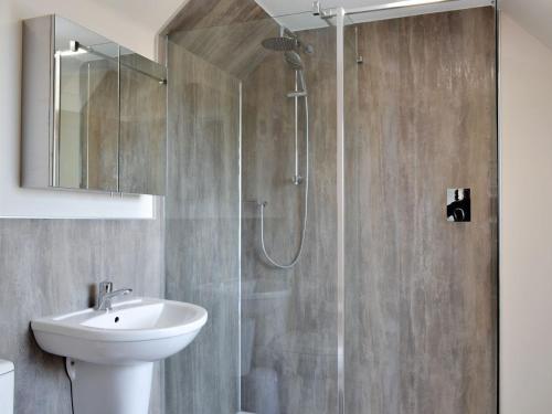 a bathroom with a shower with a sink and a toilet at Inver House Apartment in Inverurie