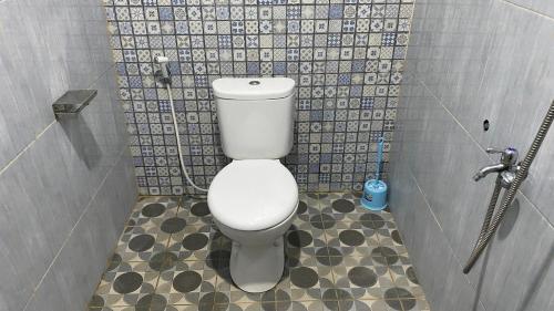 a bathroom with a white toilet in a stall at Homestay Candi Pawon Murtakim Syariah in Mendut