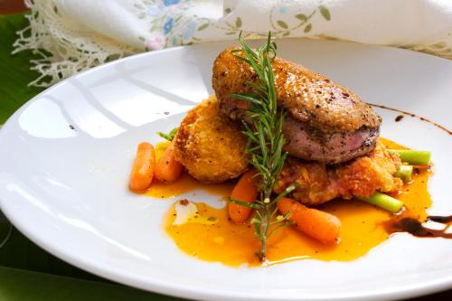 a plate of food with chicken and carrots on a table at ON Hotel Phuket - SHA in Karon Beach
