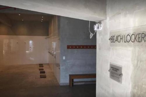 une chambre avec un banc et un panneau sur un mur dans l'établissement Hermoso apartamento en Ocean Reef San Bartolo, con acceso piscina y área sociales!, à San Bartolo