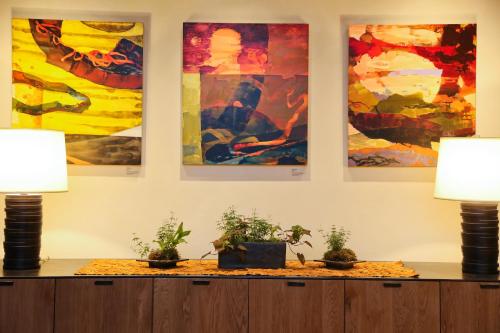 a room with three paintings on the wall with potted plants at Hotel Vermont Burlington in Burlington