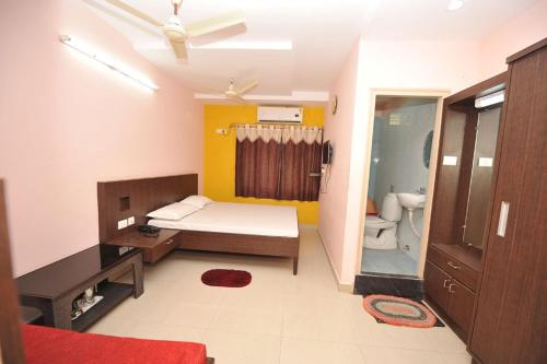 a bedroom with a bed and a bathroom with a toilet at Shree Lakshmi Guest House in Visakhapatnam