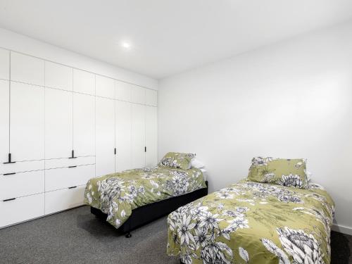 a bedroom with two beds and a white cabinet at 541 - 3 Bedroom Townhouse - Centrally Located- Free Parking - Free WIFI in Torquay