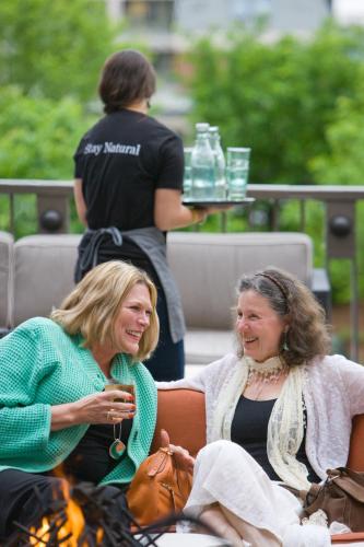 two women sitting next to each other in front of a fire at Hotel Vermont Burlington in Burlington