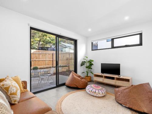 a living room with a couch and a flat screen tv at 541 - 3 Bedroom Townhouse - Centrally Located- Free Parking - Free WIFI in Torquay