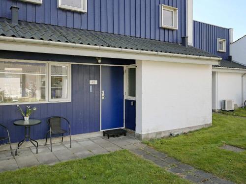 a blue and white house with a table and chairs at 5 person holiday home in Væggerløse-By Traum in Bøtø By