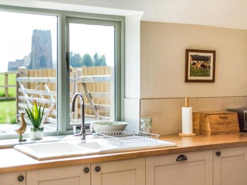 encimera de cocina con fregadero y ventana en Tadpole Mews At Frog Hall en Tilston