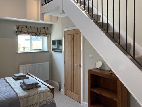 a bedroom with a bed and a staircase at Tadpole Mews At Frog Hall in Tilston