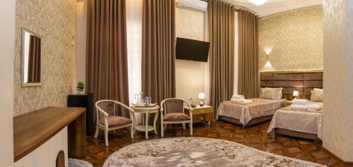 a hotel room with two beds and a table and chairs at Renaissance Boutique Hotel in Samarkand