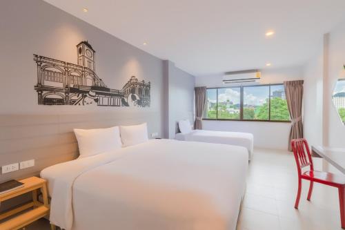 a hotel room with a white bed and a window at Recenta Style Phuket Town in Phuket Town