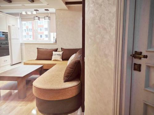 a living room with a couch and a stool at Stunning new design apartment next to park in Chişinău
