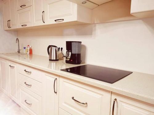 a kitchen counter with a coffee maker on it at Stunning new design apartment next to park in Chişinău