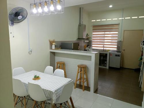 a kitchen with a table and stools in a kitchen at ZR D'Chili Homestay, Kemaman in Cukai