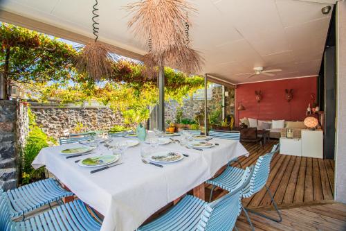 une longue table avec des chaises bleues dans un restaurant dans l'établissement Couleur Sables - belle villa avec piscine chauffée - St Gilles les Bains Grand Fond, à Saint-Gilles les Bains