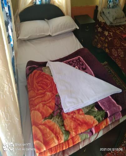 a bed with a bunch of blankets on it at Chiten Homestay by StayApart in Sonāda