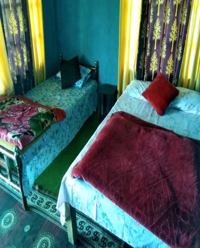 a bedroom with two beds with colorful sheets at Chiten Homestay by StayApart in Sonāda