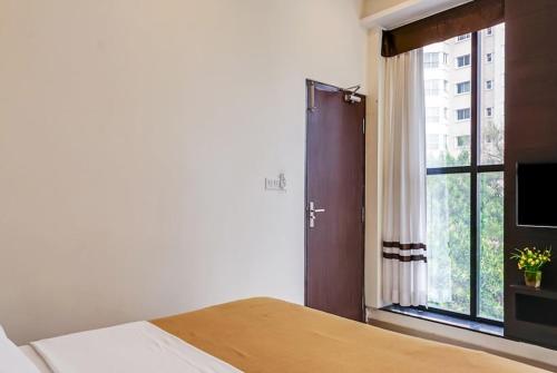a bedroom with a bed and a large window at Ajantha Komforts, Bengaluru in Bangalore