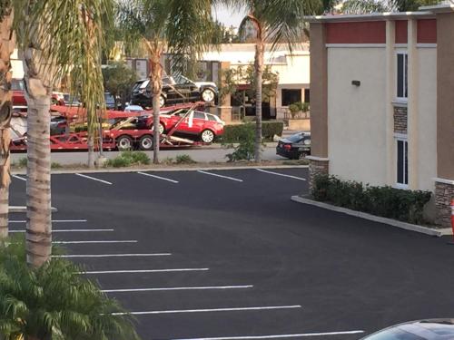 a parking lot with cars parked in a parking lot at Ontario Inn & Suites in Montclair