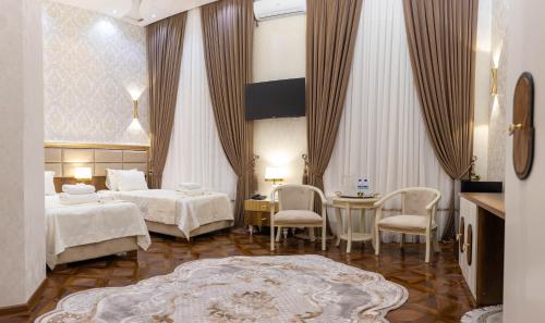 a hotel room with two beds and a table and chairs at Renaissance Boutique Hotel in Samarkand