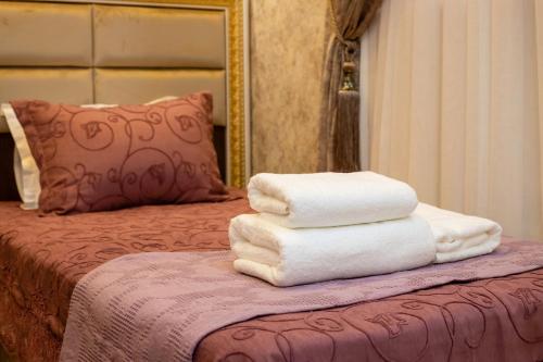 a pile of towels sitting on top of a bed at Renaissance Boutique Hotel in Samarkand