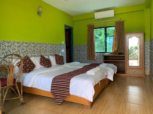 una camera da letto con un letto grande con pareti verdi di Lake Vision Guesthouse a Pokhara