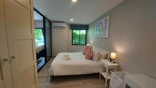 una piccola camera con un letto bianco e una finestra di Cozy Apartment Close to Amazing Beach ! 39 Sqm a Phuket
