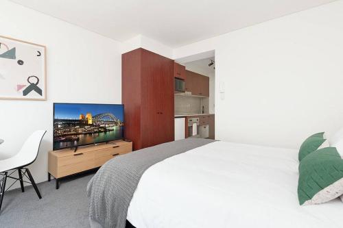 a bedroom with a large bed and a television in it at MP303 - Studio Apartment, Military Road, Cremorne in Sydney