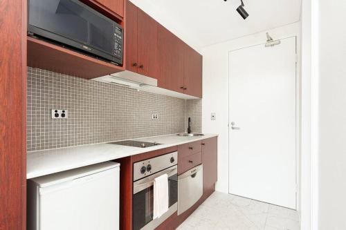 a kitchen with a stove and a microwave at MP303 - Studio Apartment, Military Road, Cremorne in Sydney