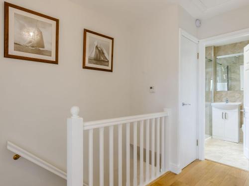 pasillo blanco con escalera y lavabo en Stocks Cottage en Blockley